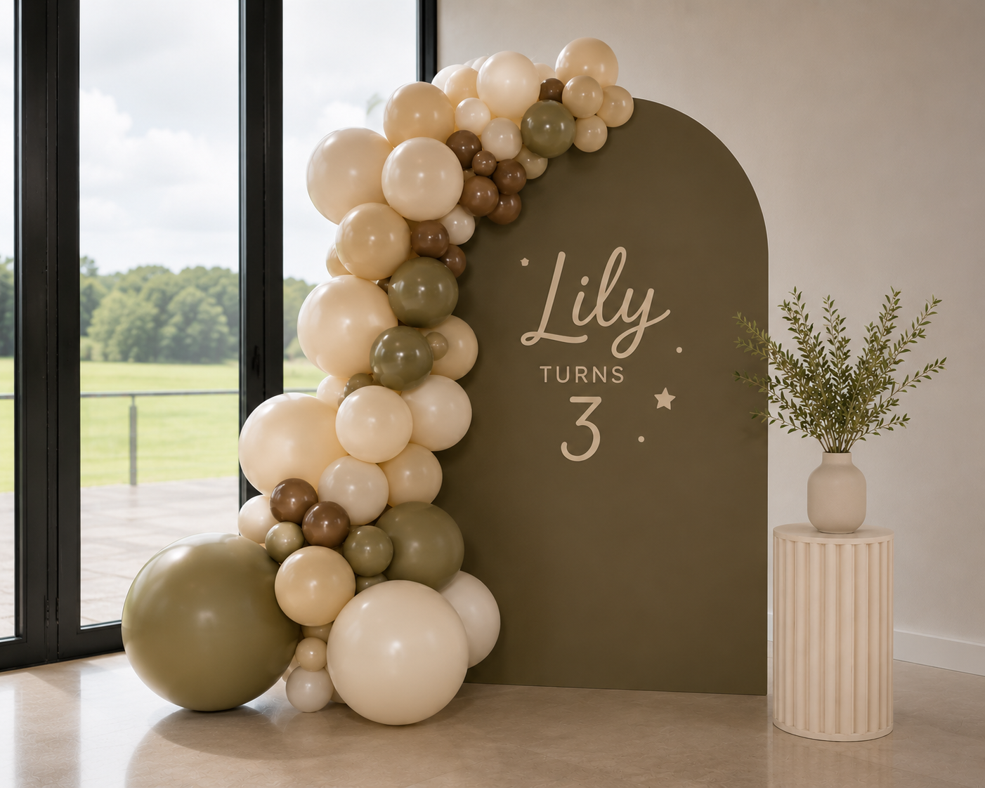 Rose and Rae olive arch and balloon garland styled for Lily's third birthday